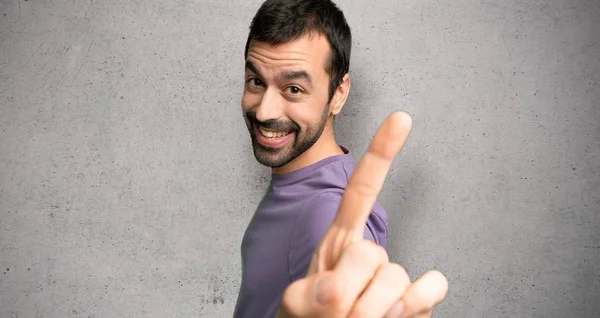 Bonito Homem Mostrando Levantando Dedo Sobre Parede Texturizada — Fotografia de Stock