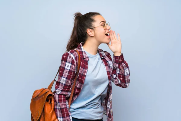 Tiener Student Meisje Geïsoleerde Blauwe Muur Schreeuwen Met Mond Wijd — Stockfoto