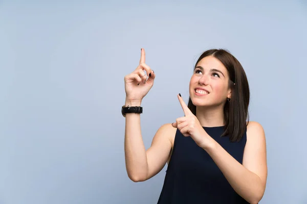 Jonge Vrouw Geïsoleerde Blauwe Muur Wijzend Met Wijsvinger Een Geweldig — Stockfoto