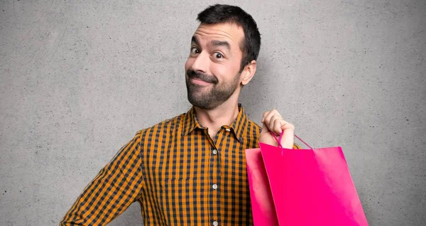 Mann Mit Einkaufstaschen Posiert Mit Armen Der Hüfte Und Blickt — Stockfoto