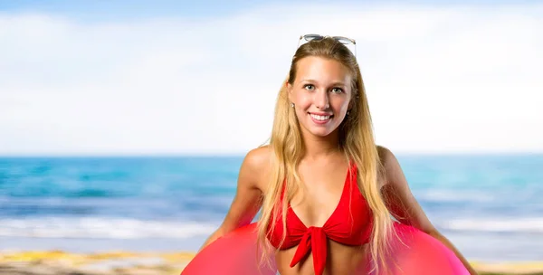 Gelukkige blonde vrouw in zomer vakantie op het strand — Stockfoto