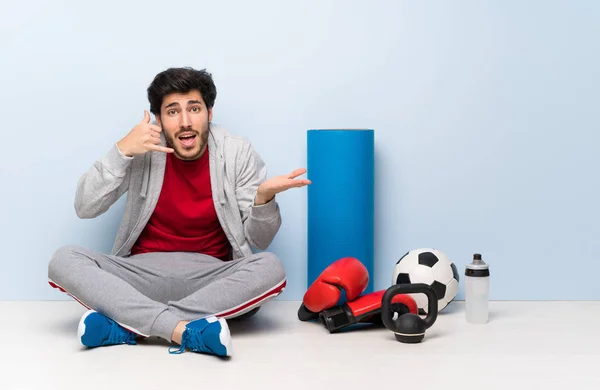 Deportivo Sentado Suelo Haciendo Gesto Telefónico Dudando — Foto de Stock