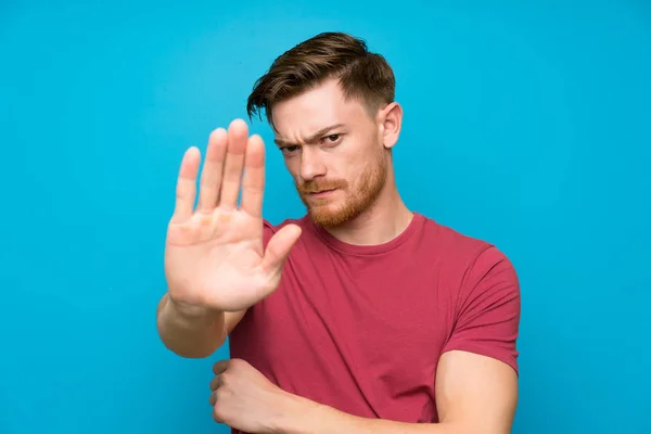 Κοκκινομάλλης Άνθρωπος Απομονωμένο Μπλε Τοίχο Κάνοντας Στάση Χειρονομία Χέρι Της — Φωτογραφία Αρχείου