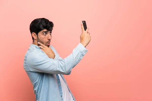 Genç Adam Üzerinde Pembe Duvar Yapmak Bir Selfie — Stok fotoğraf