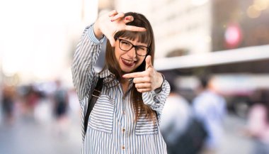 Gözlüklü kadın, yüzüne odaklanıyor. Açık havada çerçeveleme sembolü