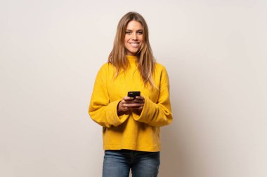 Mobil ileti gönderme izole duvarın üzerinden sarı kazaklı kadın