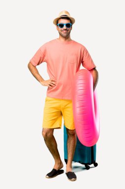 Onun yaz tatilinde şapka ve güneş gözlüğü ile Man Tam vücut kalça kolları ile poz ve izole arka plan üzerinde gülümseyerek