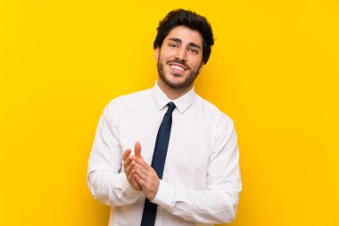 İzole sarı arka plan üzerinde işadamı alkışlıyor