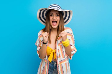 Yaz tatilinde bikinili genç bir kadın galibiyeti kutluyor.