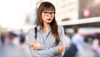 Gözlüklü kadın açık havada şüpheleri olan lateraller işaret