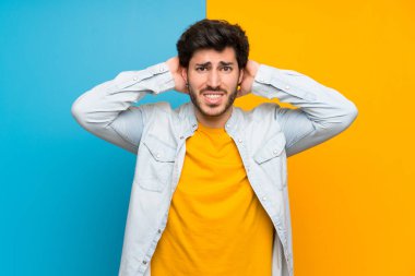 Izole renkli arka plan üzerinde Yakışıklı sinirli ve baş elleri alır