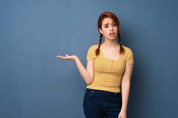Young Redhead Woman Blue Background Serious While Holding Copyspace Imaginary — 스톡 사진