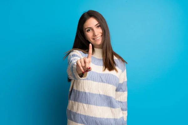 Mujer Joven Sobre Pared Azul Mostrando Levantando Dedo —  Fotos de Stock
