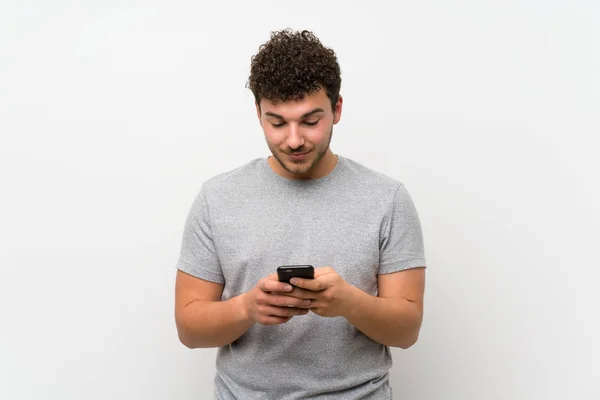 Man Curly Hair Isolated Wall Using Mobile Phone — Stock Photo, Image