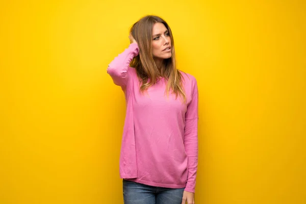 Woman Pink Sweater Yellow Wall Having Doubts While Scratching Head — ストック写真