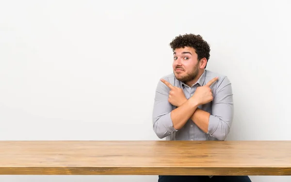 Young Man Table Pointing Laterals Having Doubts — Stock Photo, Image