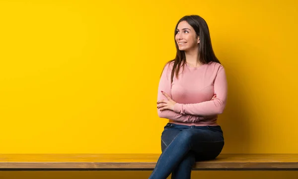 Jovem Mulher Sentada Mesa Olhando Para Cima Enquanto Sorri — Fotografia de Stock