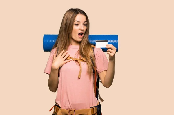 Jonge Backpacker Vrouw Met Een Creditcard Verrast Geïsoleerde Gele Achtergrond — Stockfoto