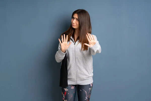 Young sport woman nervous and scared stretching hands to the front