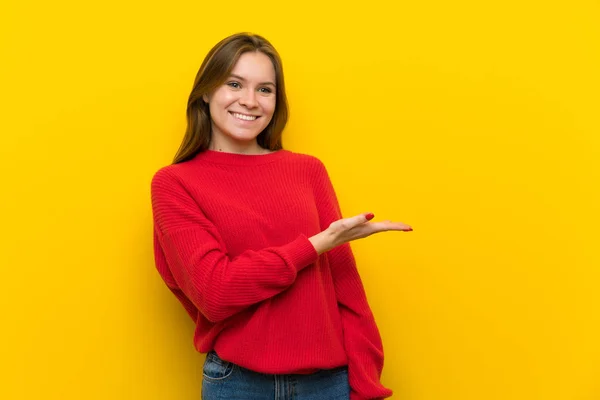 黄色の壁に向かって笑顔を探しながらアイデアを提示の上の若い女性 — ストック写真