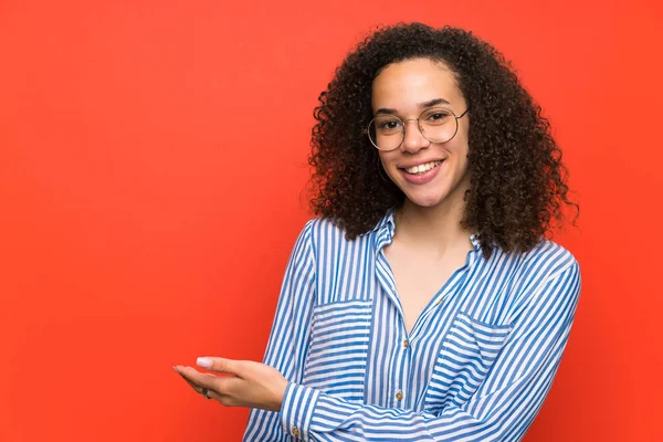 Mujer Dominicana Sobre Pared Roja Extendiendo Las Manos Lado Para —  Fotos de Stock