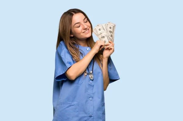 Νεαρή Νοσοκόμα Παίρνει Πολλά Χρήματα Απομονωμένο Μπλε Φόντο — Φωτογραφία Αρχείου