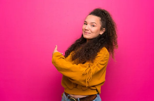 Adolescente Chica Sobre Rosa Pared Apuntando Hacia Atrás —  Fotos de Stock