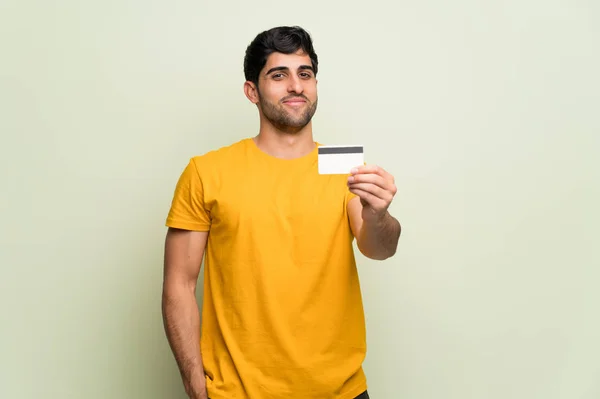 Mladý Muž Přes Růžovou Zeď Drží Kreditní Kartu — Stock fotografie
