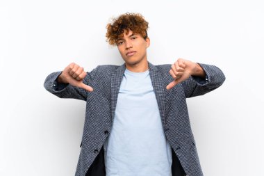 Izole beyaz duvar üzerinde Moda afro-amerikan adam başparmak aşağı gösteren