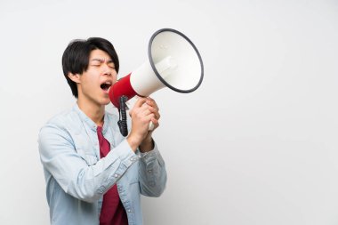 Bir megafon ile bağırarak izole beyaz arka plan asyalı adam