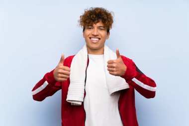 Genç Afro-Amerikan sporcusu, baş parmak hareketi yapıyor.