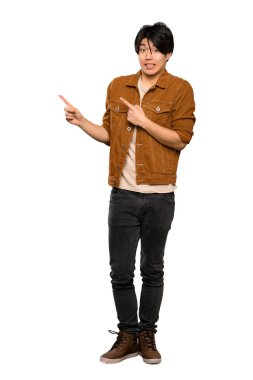 Kahverengi ceketli Asyalı bir adamın tam uzunlukta bir fotoğrafı korkmuş ve izole beyaz arka plan üzerinde yan işaret