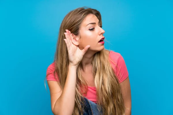 Young Blonde Woman Overalls Isolated Blue Wall Listening Something Putting — Stock Photo, Image