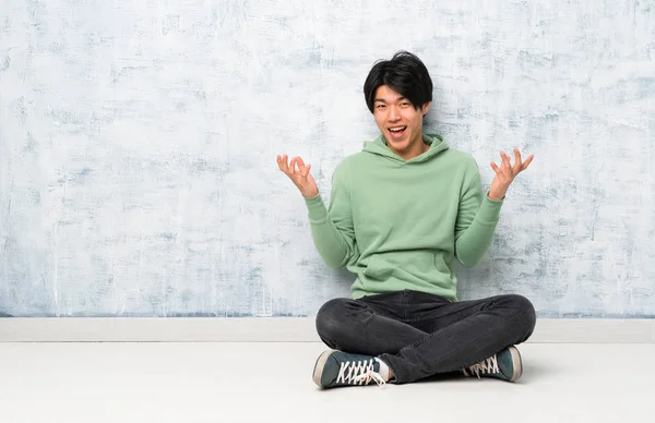Asiatischer Mann Sitzt Auf Dem Boden Und Lächelt Viel — Stockfoto