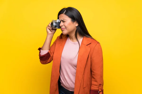 Junge Kolumbianische Mädchen Über Gelbe Wand Hält Eine Kamera — Stockfoto