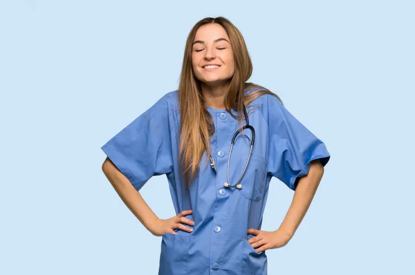 Νεαρή Νοσοκόμα Χαρούμενη Και Χαμογελαστή Απομονωμένο Μπλε Φόντο — Φωτογραφία Αρχείου