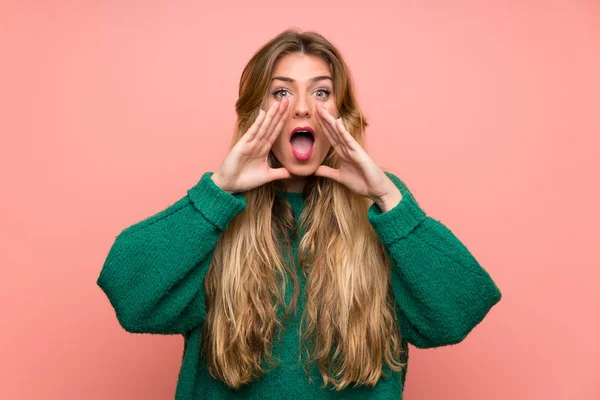 Young Blonde Woman Green Sweater Pink Wall Shouting Mouth Wide — 스톡 사진
