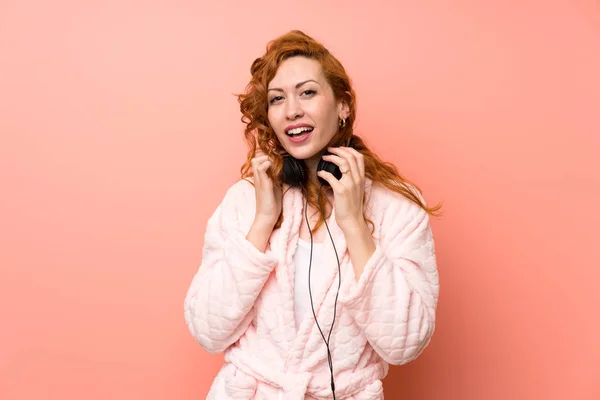 빨간 머리 여자 에 드레싱 가운 듣기 음악 — 스톡 사진