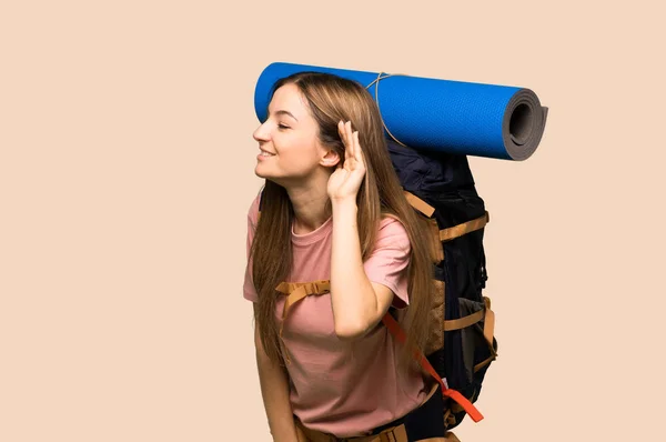 Young Backpacker Woman Listening Something Putting Hand Ear Isolated Yellow — Stock Photo, Image