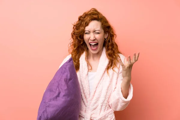 Redhead woman in dressing gown unhappy and frustrated with something