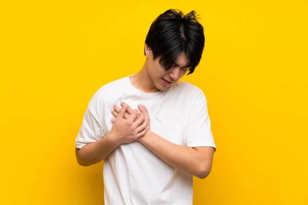 Asiatische Mann Über Isolierte Gelbe Wand Mit Einem Schmerz Herzen — Stockfoto