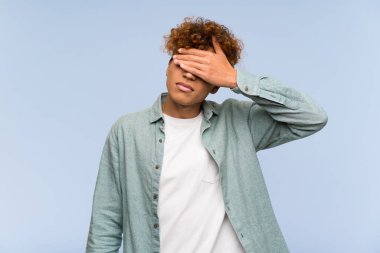 Genç Afro-Amerikan bir adam, mavi duvarın üzerinde, gözleri elleriyle kapatıyor. Bir şey görmek istemiyorum.