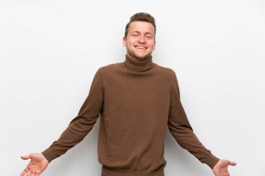 Gülümseyen izole beyaz duvar üzerinde sarışın adam