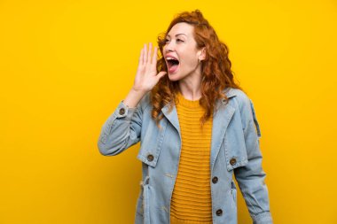 Izole sarı arka plan üzerinde Redhead kadın ağzı tamamen açık bağırarak