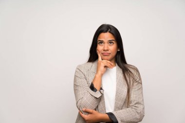 Beyaz duvarın ötesindeki genç Kolombiyalı kız bir fikir düşünüyor.