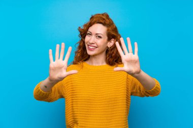 Sarı kazak parmakları ile on sayma redhead kadın