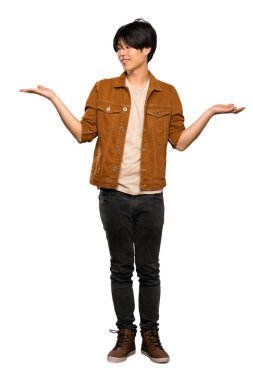 İzole beyaz arka plan üzerinde iki eliyle copyspace tutan kahverengi ceketli Asyalı bir adamın tam uzunlukta bir çekim