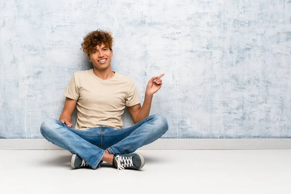 Junger Afrikanisch Amerikanischer Mann Sitzt Auf Dem Boden Und Zeigt — Stockfoto