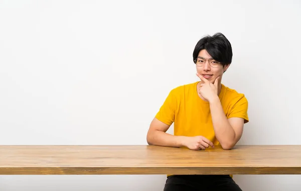 Asian man with yellow shirt with glasses and happy