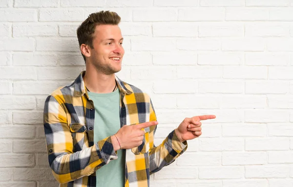 Blonder Schöner Mann Über Weiße Backsteinmauer Der Mit Dem Finger — Stockfoto